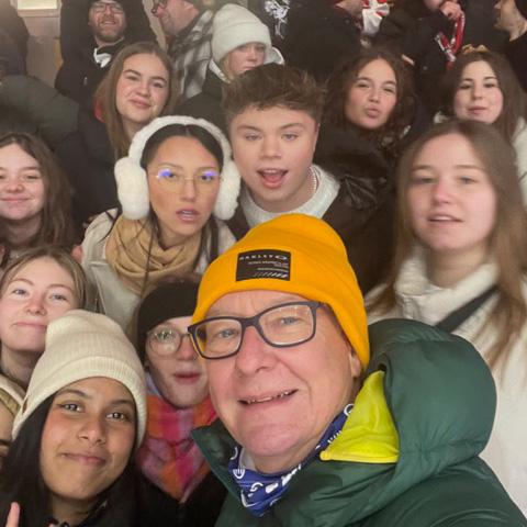 Fröhliche Schülerinnen und Schüler mit ihrem Lehrer beim Eishockeyspiel Exkursion des BG zum Eishockeyspiel