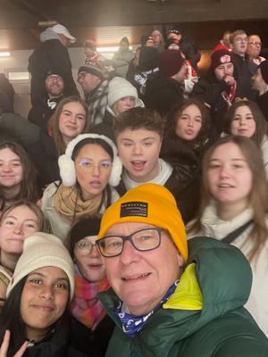 Exkursion des BG-Sportkurses zum Eishockey Fröhliche Schülerinnen und Schüler mit ihrem Lehrer beim Eishockeyspiel