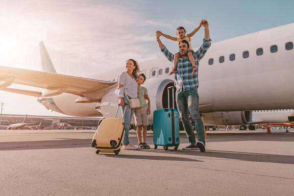Familie vor Flugzeug auf dem Weg in den Urlaub