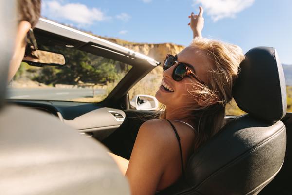 Glückliches Pärchen fährt mit Mietwagen im Urlaub