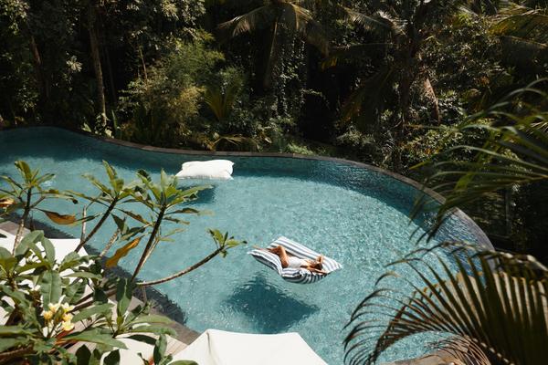 Frau die in einem Infinity Pool 5 Sterne Hotel entspannt