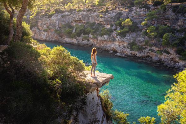 Cala Pi Mallorca Frau steht auf Aussichtsplattform mit Blick über Bucht